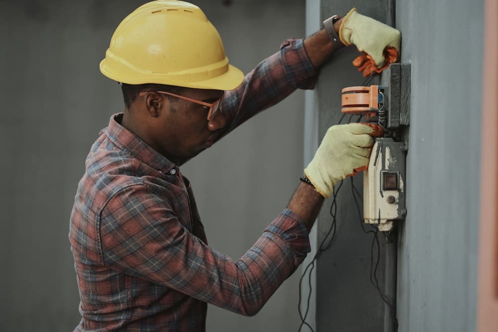 Electrician in a hard hat working a service upgrade