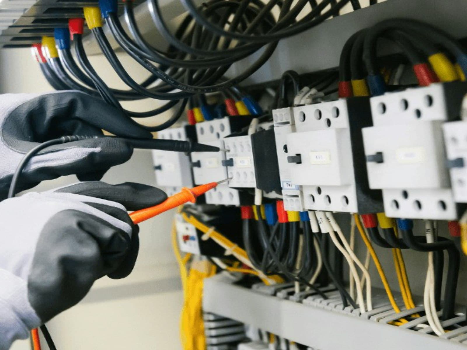 Fieldline electrician testing a residential panel with a multimeter